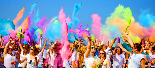 Crowd of festival-goers covered in colourful Holi powder